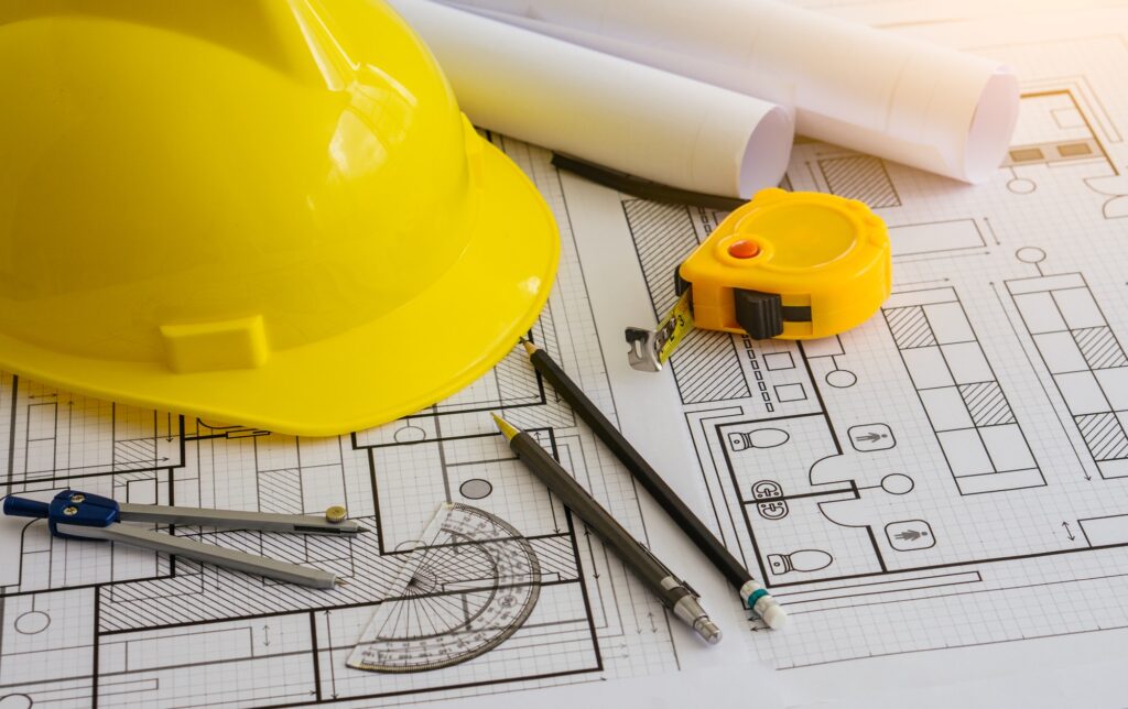 Architectural equipment and constuction hat on table.